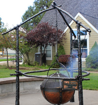 Hand forged fire pit with copper cauldron, iron logs tied with hand forged knots and rope